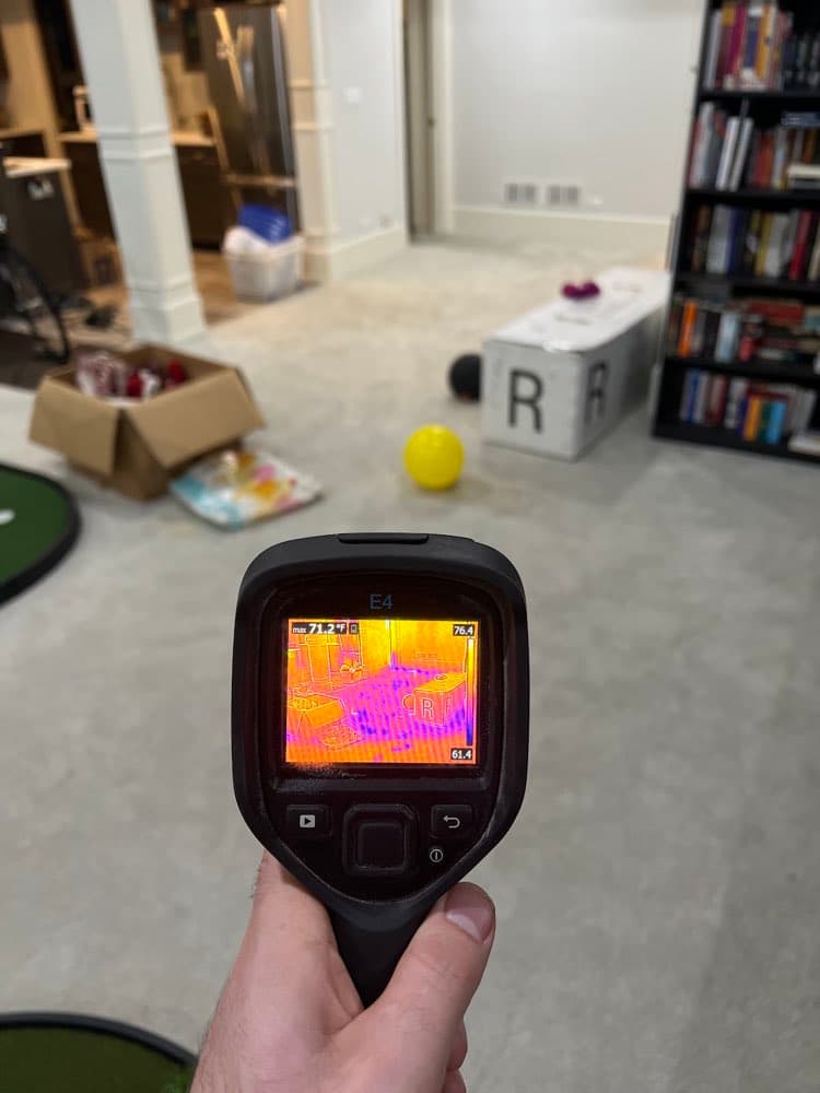 Thermal imaging camera scanning a carpeted floor for hidden moisture