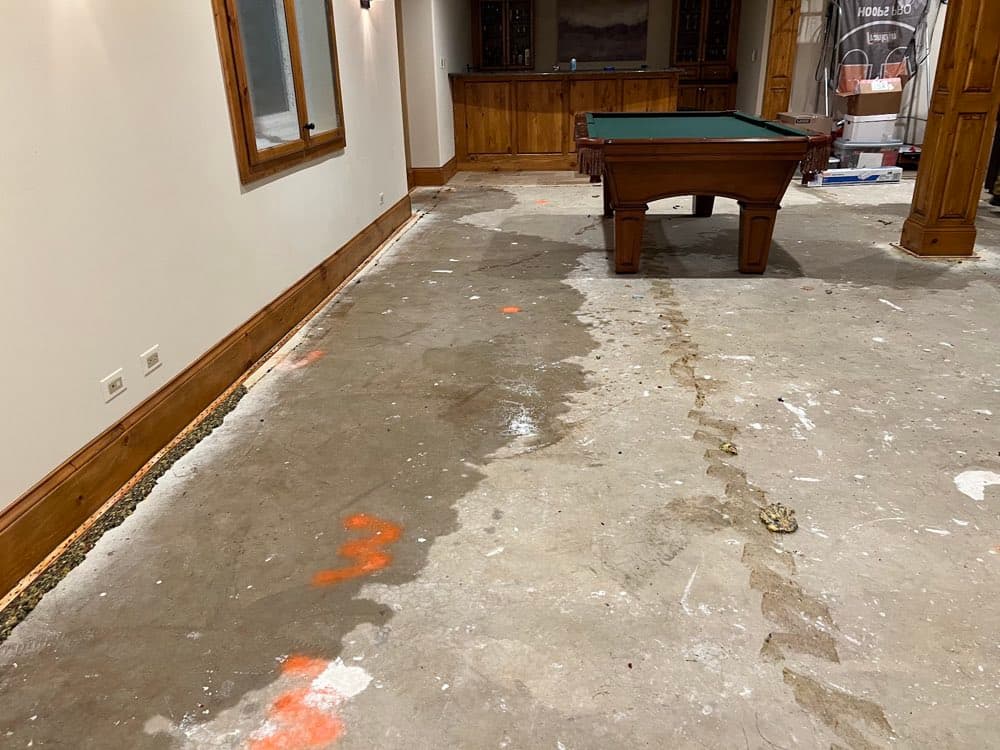Basement floor stripped for drying, pool table protected — a real Flash job
