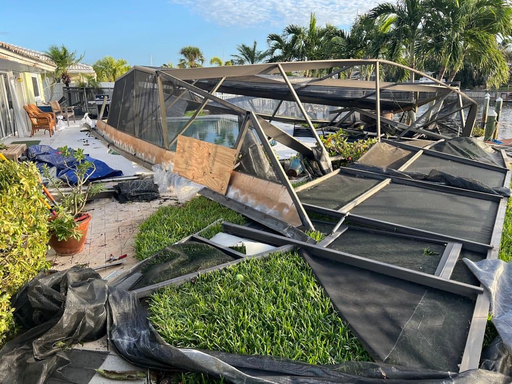 Hurricane-wrecked pool enclosure on a storm response job
