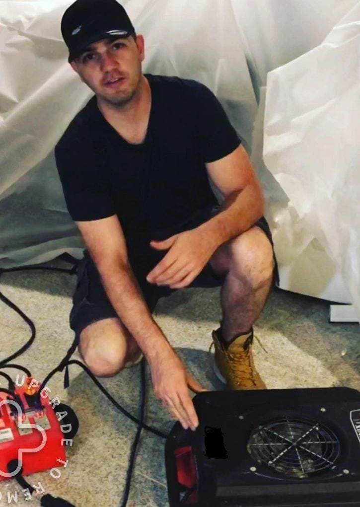 A Flash crew member setting drying equipment under containment on a real job